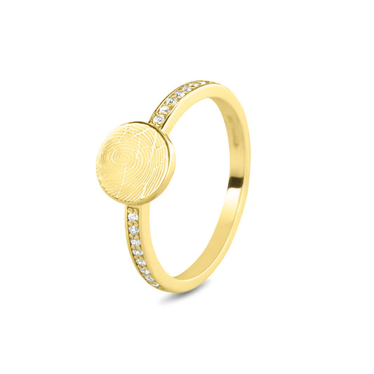 Ring 2 mm breed voorzien van een vingerafdruk/gravure, de ringband is in de bovenste helft afgewerkt met zirkonia's. Het is een tijdloos gedenksieraad en is te bestellen in zilver, 14 en 18 KT geelgoud, roségoud en witgoud.