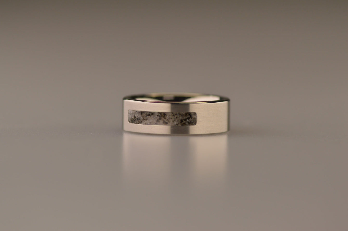 Ring als gedenksieraad 8 mm breed waar de ruimte aan de bovenzijde met as of haar verwerkt wordt. De asring is leverbaar in staal, zilver en in 14 en 18 KT geelgoud/witgoud en roségoud. Alle