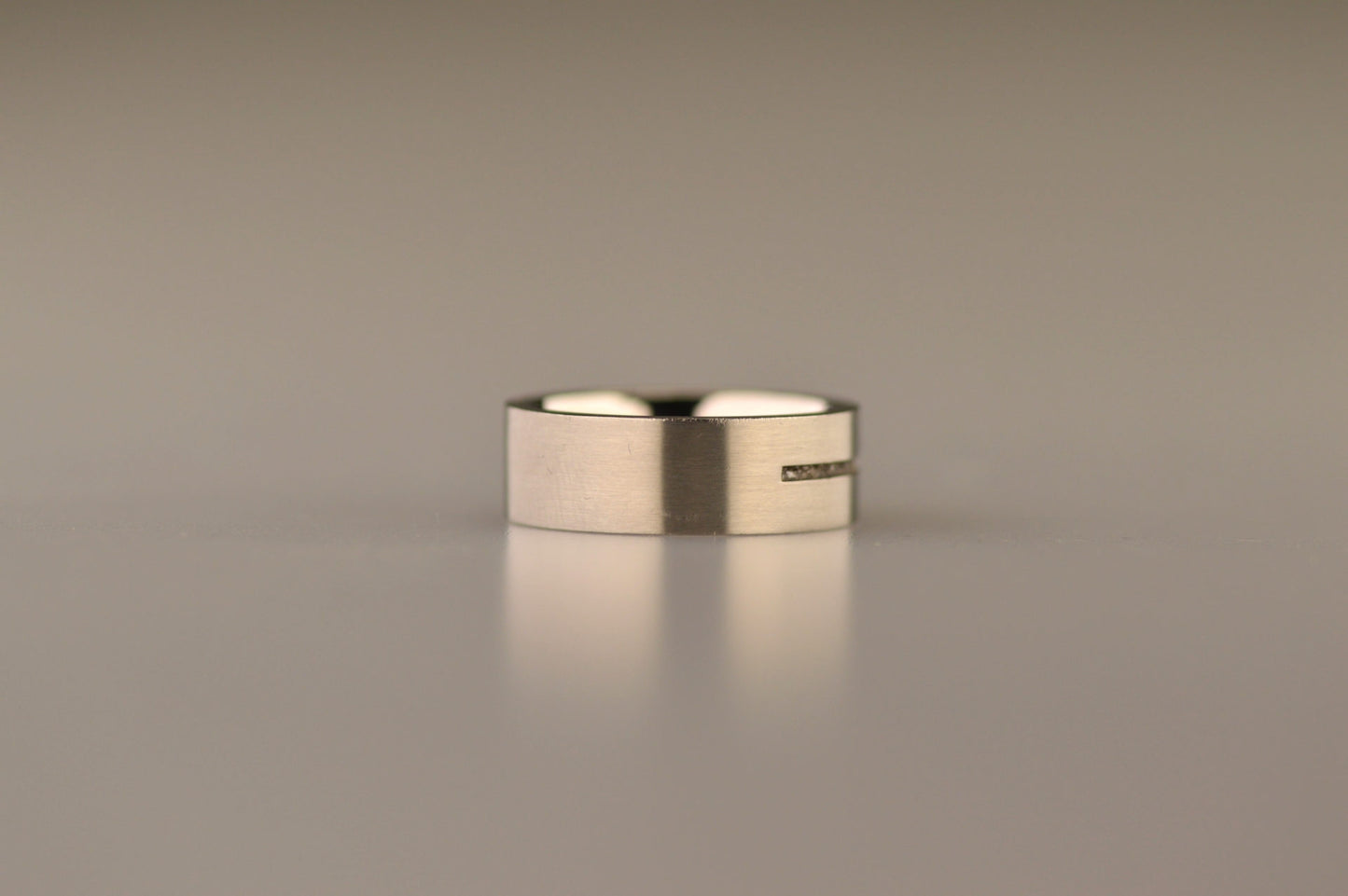 Ring als gedenksieraad 7 mm breed met één langwerpige streep waar as of haar in verwerkt wordt.De asring is leverbaar in edelstaal, zilver en in 14 en 18 KT geelgoud/witgoud en roségoud. Alle