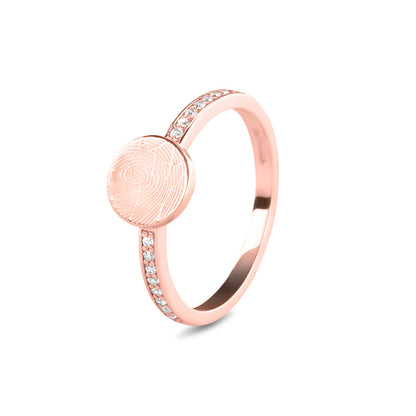Ring 2 mm breed voorzien van een vingerafdruk/gravure, de ringband is in de bovenste helft afgewerkt met zirkonia's. Het is een tijdloos gedenksieraad en is te bestellen in zilver, 14 en 18 KT geelgoud, roségoud en witgoud.