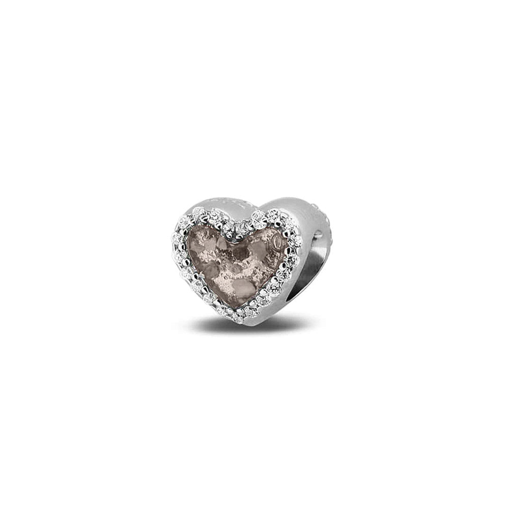 Hartvormige asbedel met  zirkonia's rondom afgewerkt, die aan beide zijdes in twee compartimenten zichtbaar gevuld wordt met as of haar met een keuze in 20 kleuren. Silver