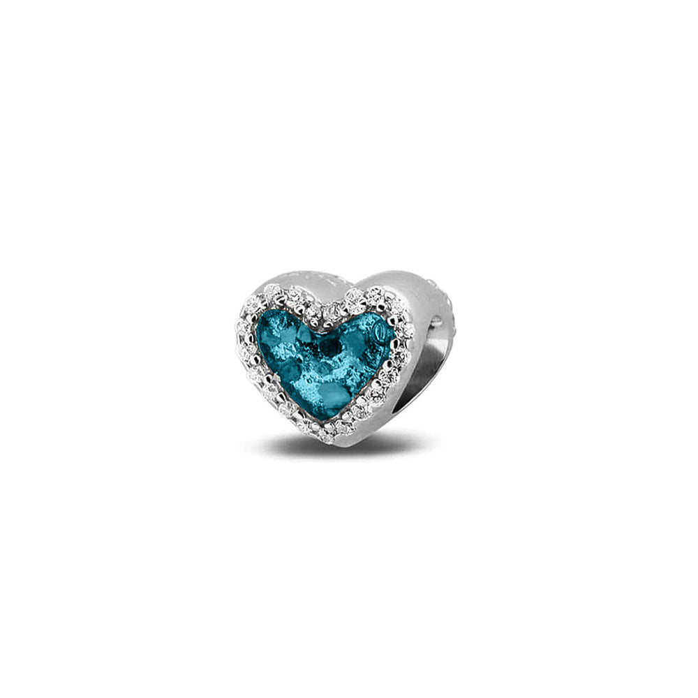 Hartvormige asbedel met  zirkonia's rondom afgewerkt, die aan beide zijdes in twee compartimenten zichtbaar gevuld wordt met as of haar met een keuze in 20 kleuren. Turquoise