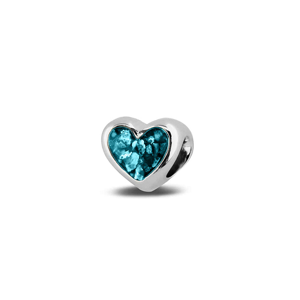 Hartvormige asbedel, aan beide zijdes zichtbaar gevuld met as of haar. Het vullen en sealen met onze speciale hars met een keuze in 20 kleuren, wordt in onze ambachtelijke edelsmederij gedaan. Turquoise