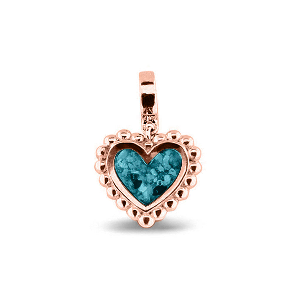 Hartvormige asbedel, die aan de voorzijde zichtbaar gevuld wordt met as of haar. Het vullen en sealen met een keuze in 20 kleuren, wordt in onze ambachtelijke edelsmederij gedaan. Turquoise