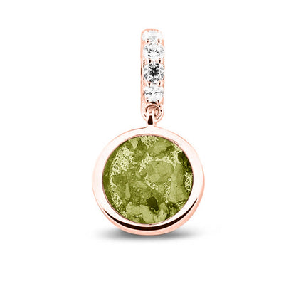 Asbedel rond subtiel design , het hangoog aan de buitenrand afgewerkt met zirkonia's, die aan de voorzijde zichtbaar gevuld wordt met as of haar met een keuze in 20 kleuren. Olive