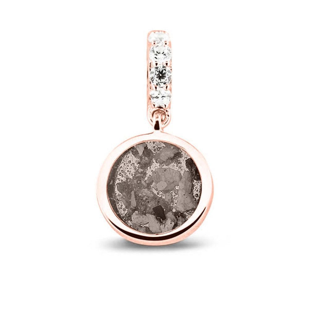 Asbedel rond subtiel design , het hangoog aan de buitenrand afgewerkt met zirkonia's, die aan de voorzijde zichtbaar gevuld wordt met as of haar met een keuze in 20 kleuren. Silver