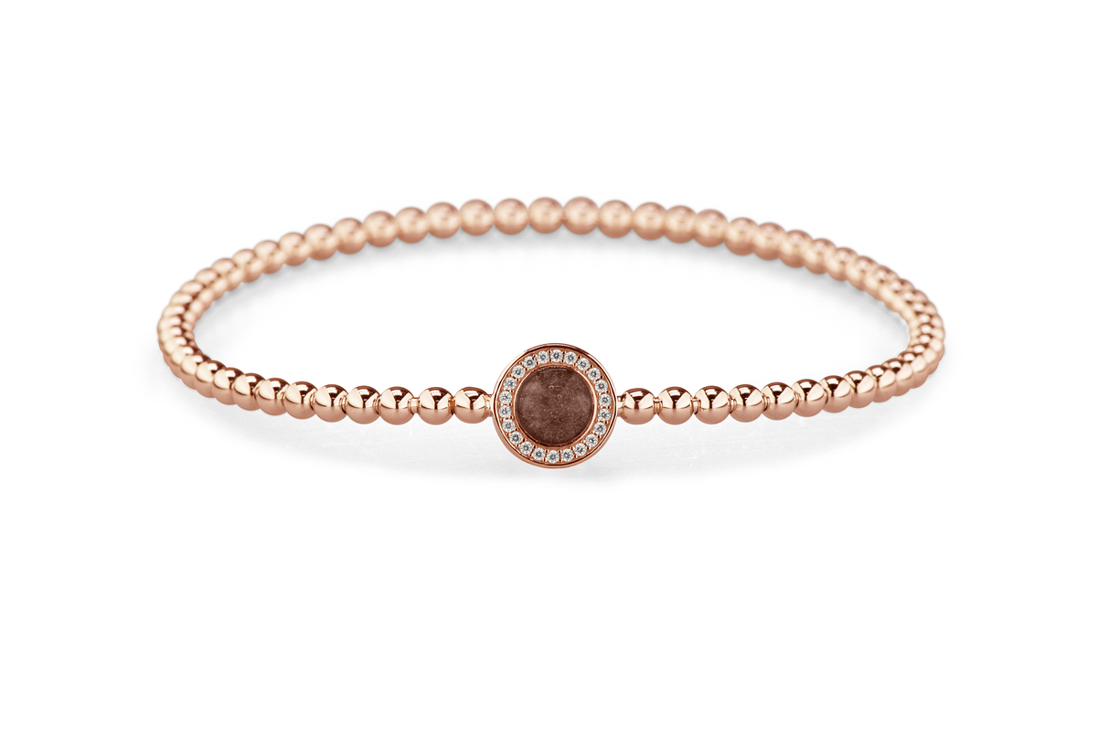 Flexibele as armband met rondje als compartiment gezet rondom met zirconia's voor as of haar. Brown