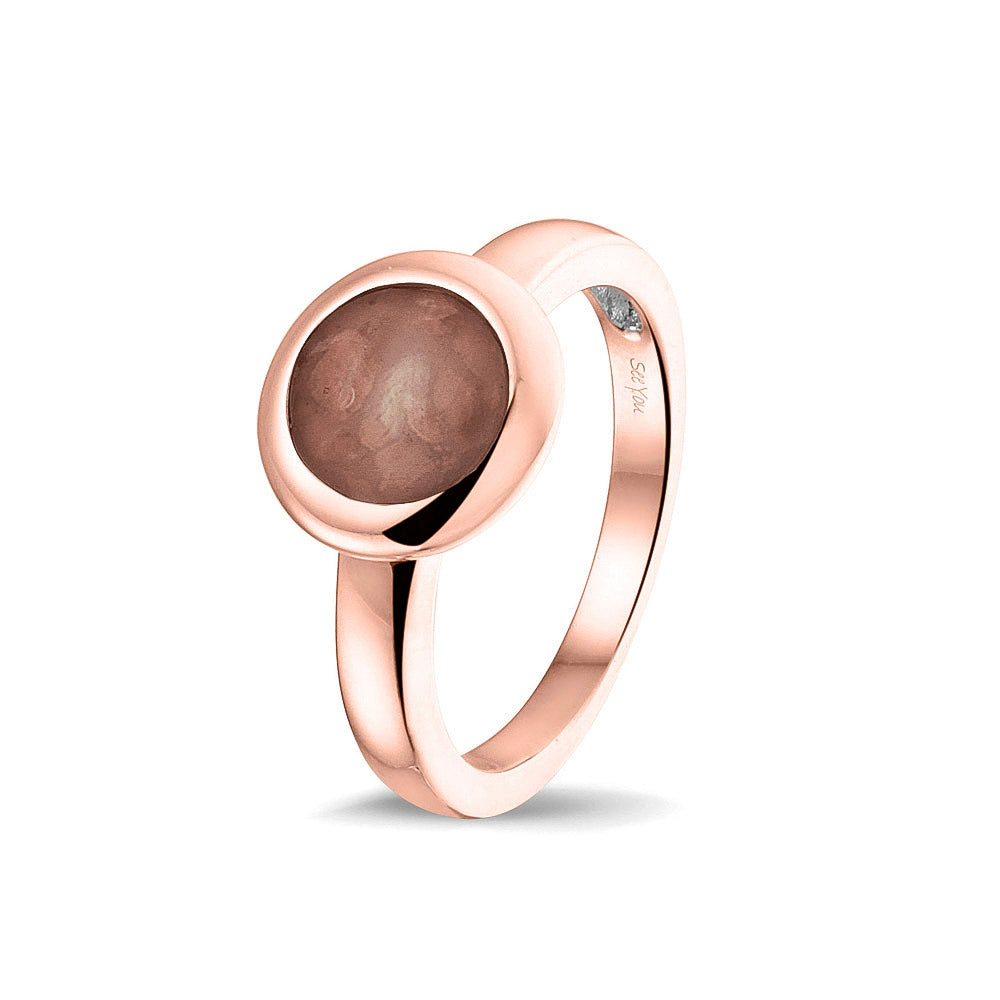 Gedenksieraad, gladde ring 3 mm waar aan de bovenzijde zichtbaar as of haar (of eventueel melktandjes of moedermelk) verwerkt wordt. Brown