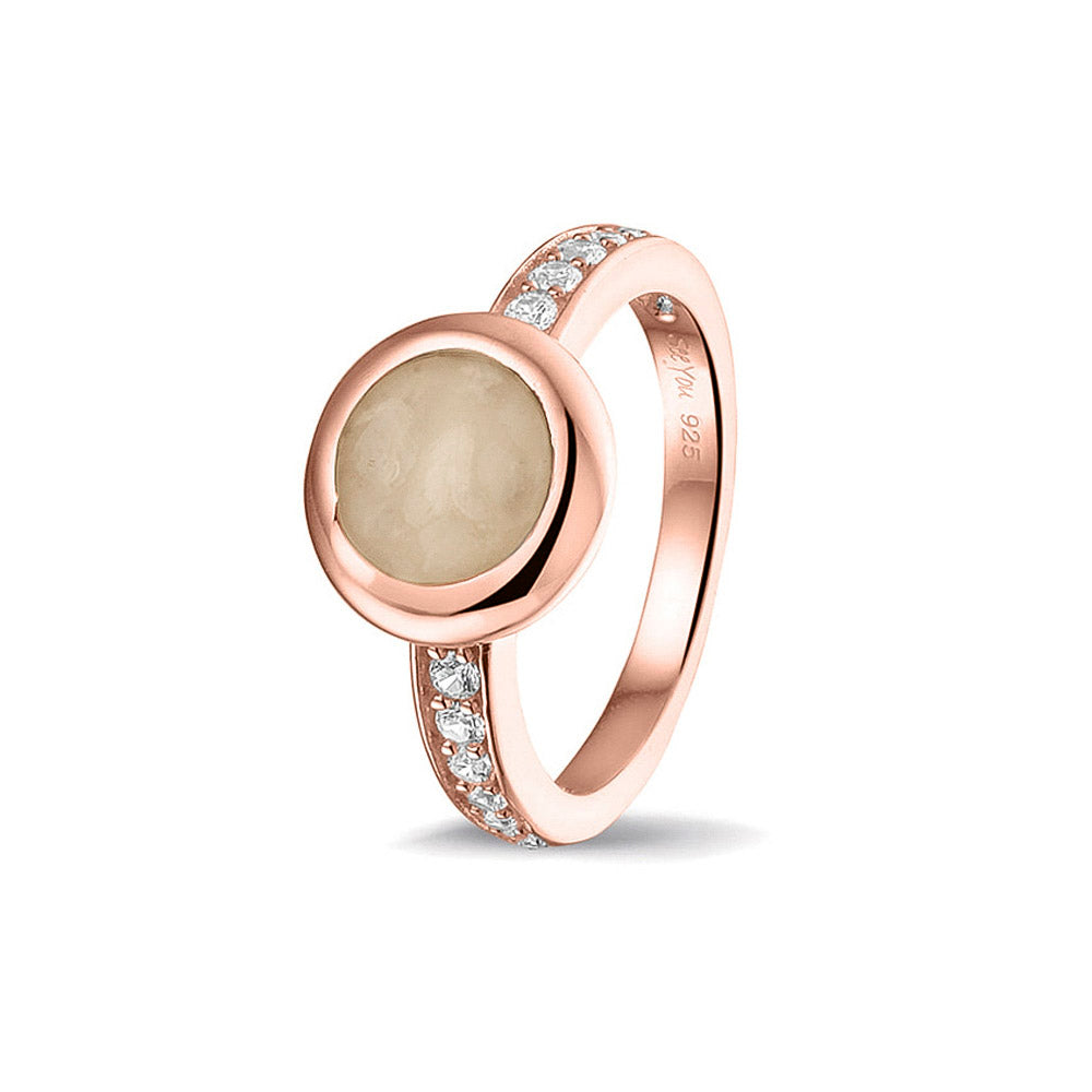 Gedenksieraad, ring 3 mm waar aan de bovenzijde zichtbaar as of haar verwerkt wordt. In de bovenste helft van de ringband zijn zirkonia's of diamanten naar keuze gezet.  Transparent