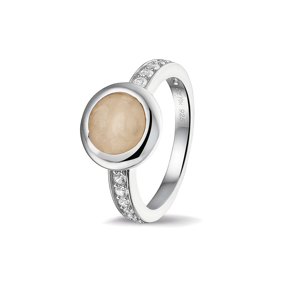 Gedenksieraad, ring 3 mm waar aan de bovenzijde zichtbaar as of haar verwerkt wordt. In de bovenste helft van de ringband zijn zirkonia's of diamanten naar keuze gezet.  Transparent