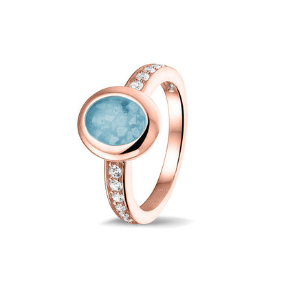 Gedenksieraad, ring 3 mm waar aan de ovale bovenzijde zichtbaar as of haar verwerkt wordt. In de bovenste helft van de ringband zijn zirkonia's of diamanten naar keuze gezet. Baby