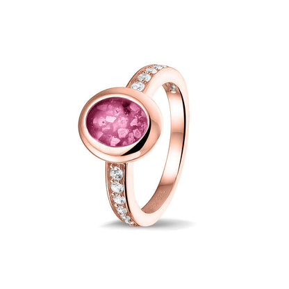 Gedenksieraad, ring 3 mm waar aan de ovale bovenzijde zichtbaar as of haar verwerkt wordt. In de bovenste helft van de ringband zijn zirkonia's of diamanten naar keuze gezet. Fluo