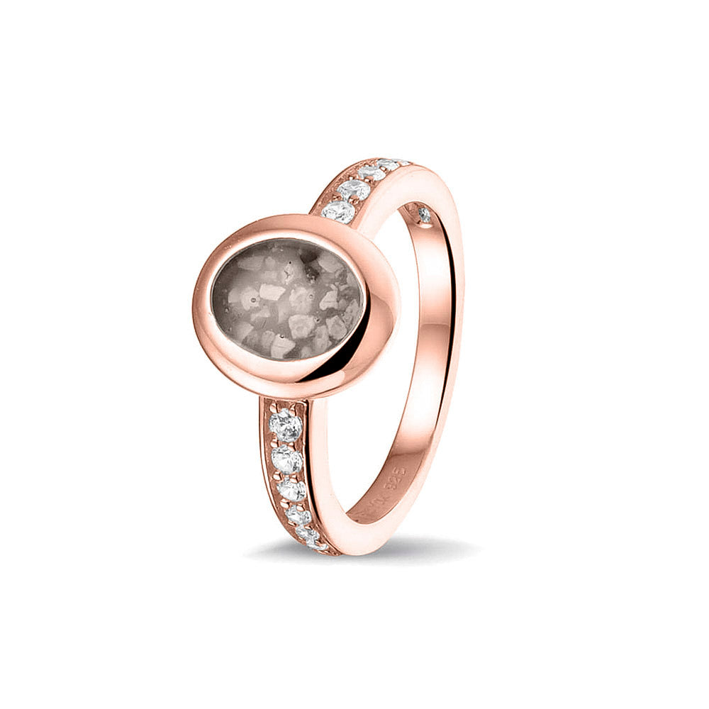 Gedenksieraad, ring 3 mm waar aan de ovale bovenzijde zichtbaar as of haar verwerkt wordt. In de bovenste helft van de ringband zijn zirkonia's of diamanten naar keuze gezet. Silver
