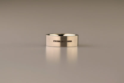 Ring als gedenksieraad 7 mm breed met één langwerpige streep waar as of haar  in verwerkt wordt.De asring is leverbaar in edelstaal, zilver en in 14 en 18 KT geelgoud/witgoud en roségoud. Alle